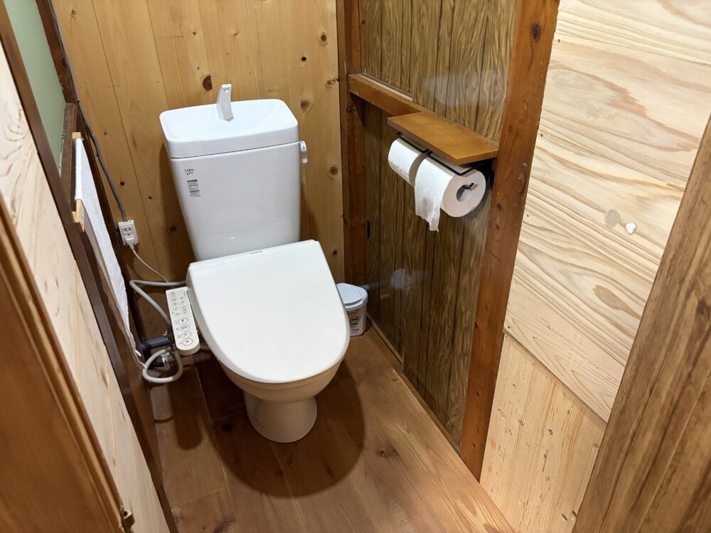木で囲まれた客室のお手洗い
