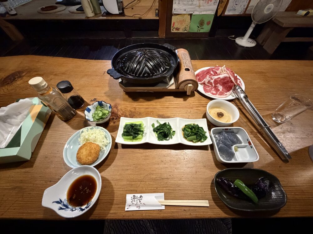 ジンギスカン鍋や小鉢が並ぶ夕食の最初の配膳